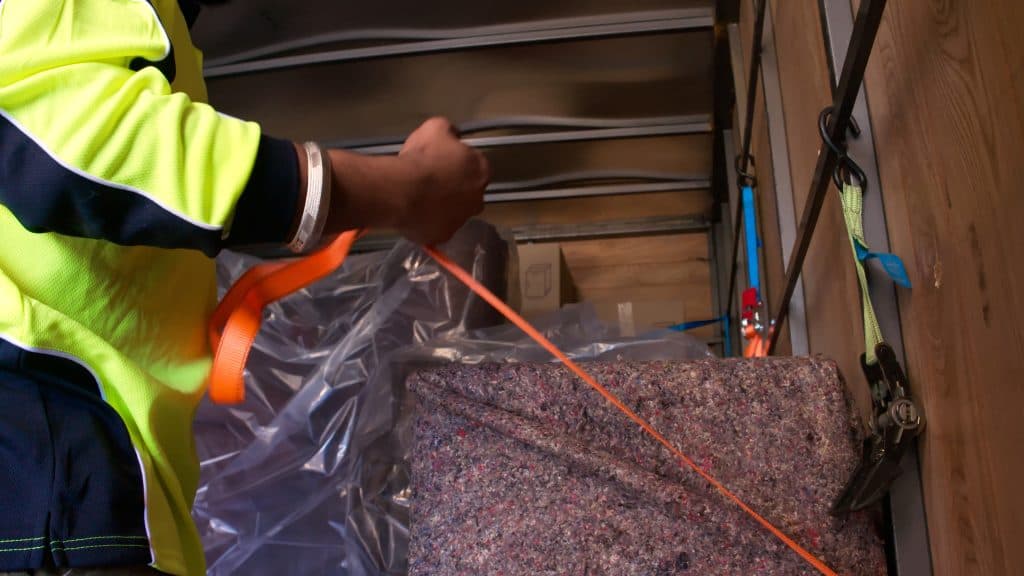 Team member securing the furniture in a truck